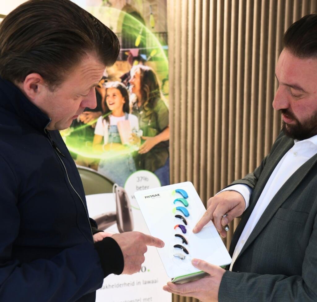 Audicien past gehoorapparaat aan bij patient - Hoorcentrum Westland